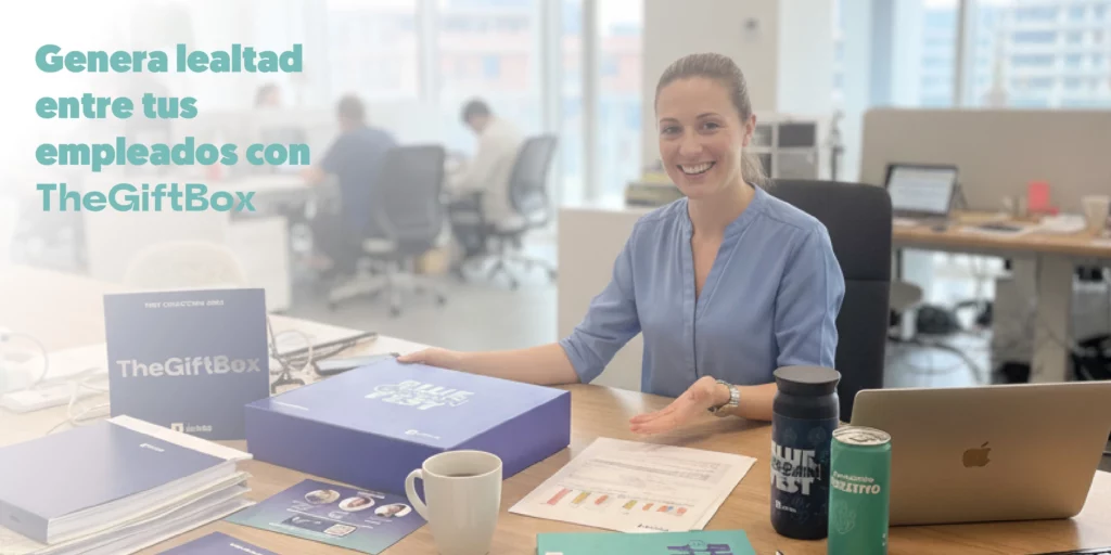 Una persona sonriendo en su sitio de trabajo recibiendo una gift box de únikas